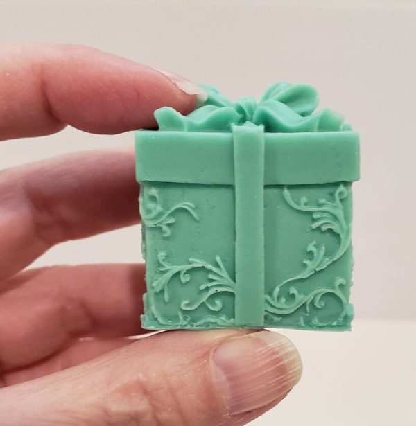green goat milk soap in the shape of a one inch cube wrapped present with a bow