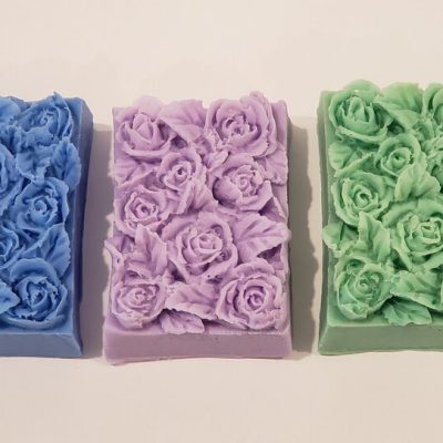 three goat milk soap bars with flower and leaf design on top