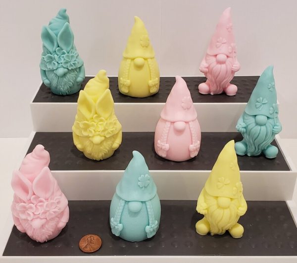 group of multi colored goat milk soap gnomes on a three level platform
