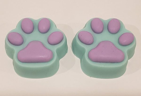 two soaps shaped like animal paws in teal with purple pads.