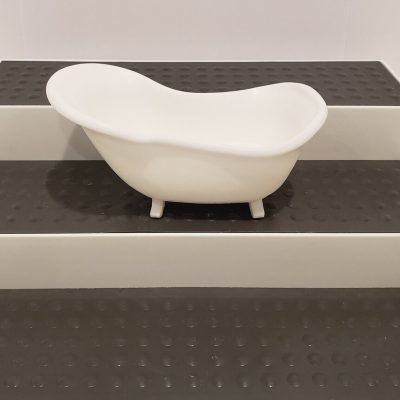 white soap shaped like a bathtub on a 3 tier shelf