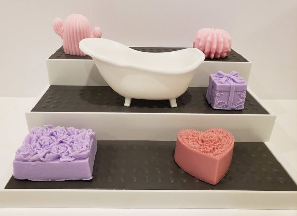bathtub shaped soap on a 3 tier shelf, with other decorative soaps around it